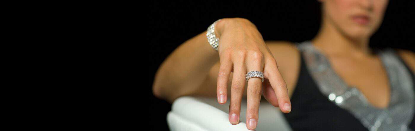 Woman showcasing jewelry at Houston Gold Exchange store.