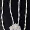 Elegante collar con colgante de rosa de diamantes y piedras brillantes sobre fondo negro.
