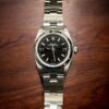 Reloj de lujo Rolex Lady No-Date con esfera negra y correa de acero inoxidable. Perfecto para una joya elegante.