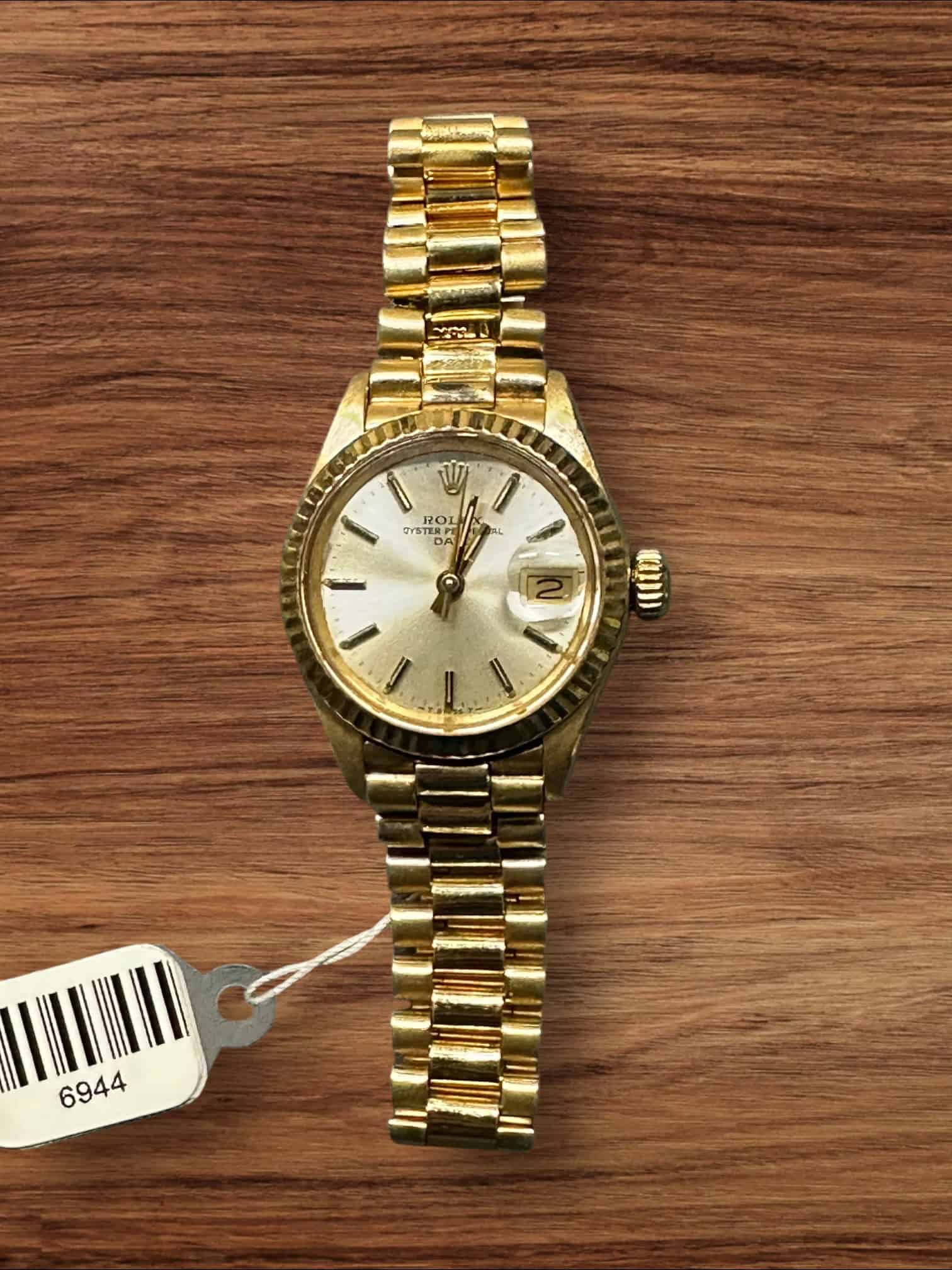 Rolex Lady President gold watch with diamond hour markers and date display.