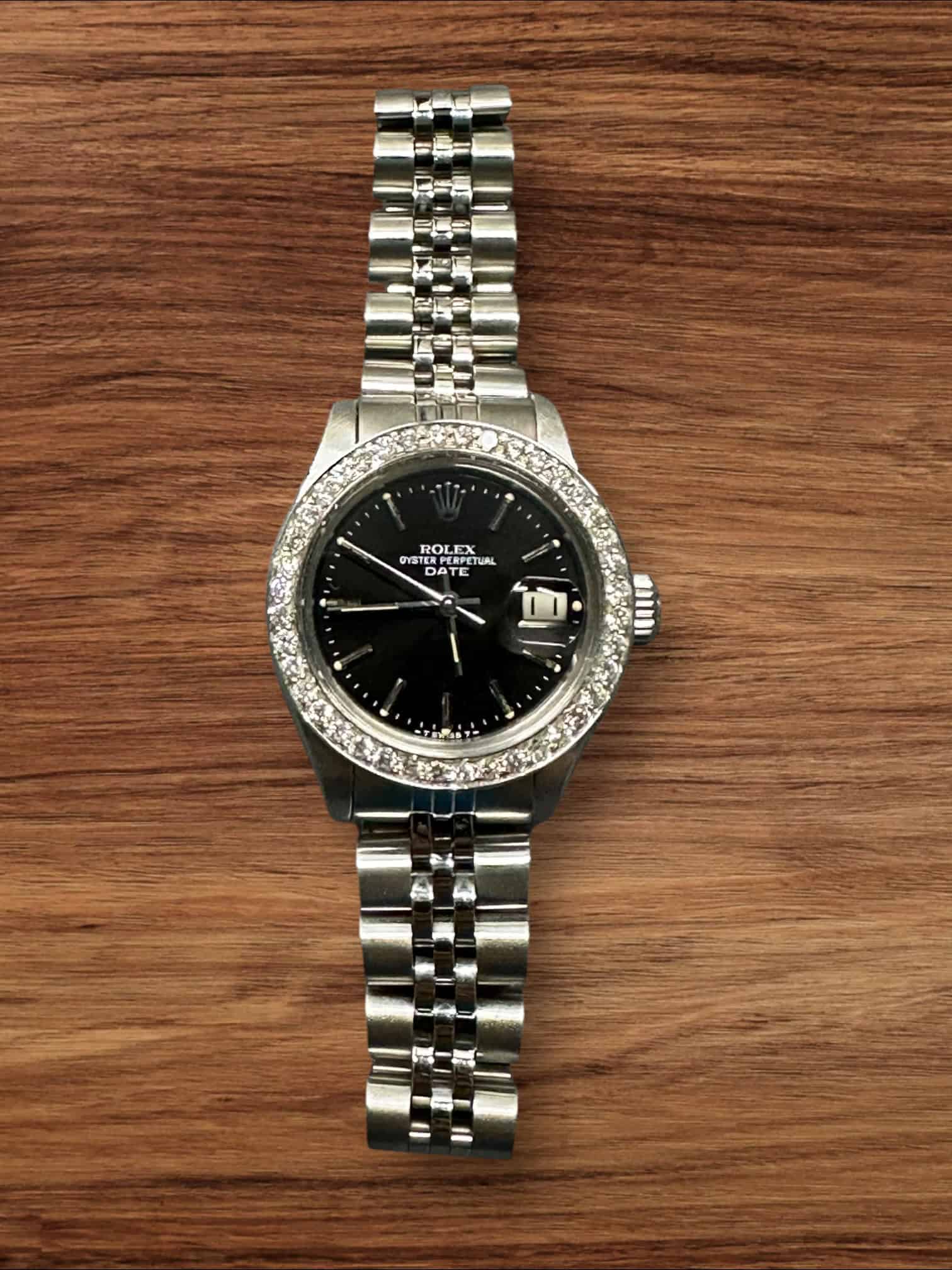 Rolex Lady Date luxury watch with diamond bezel and black dial.