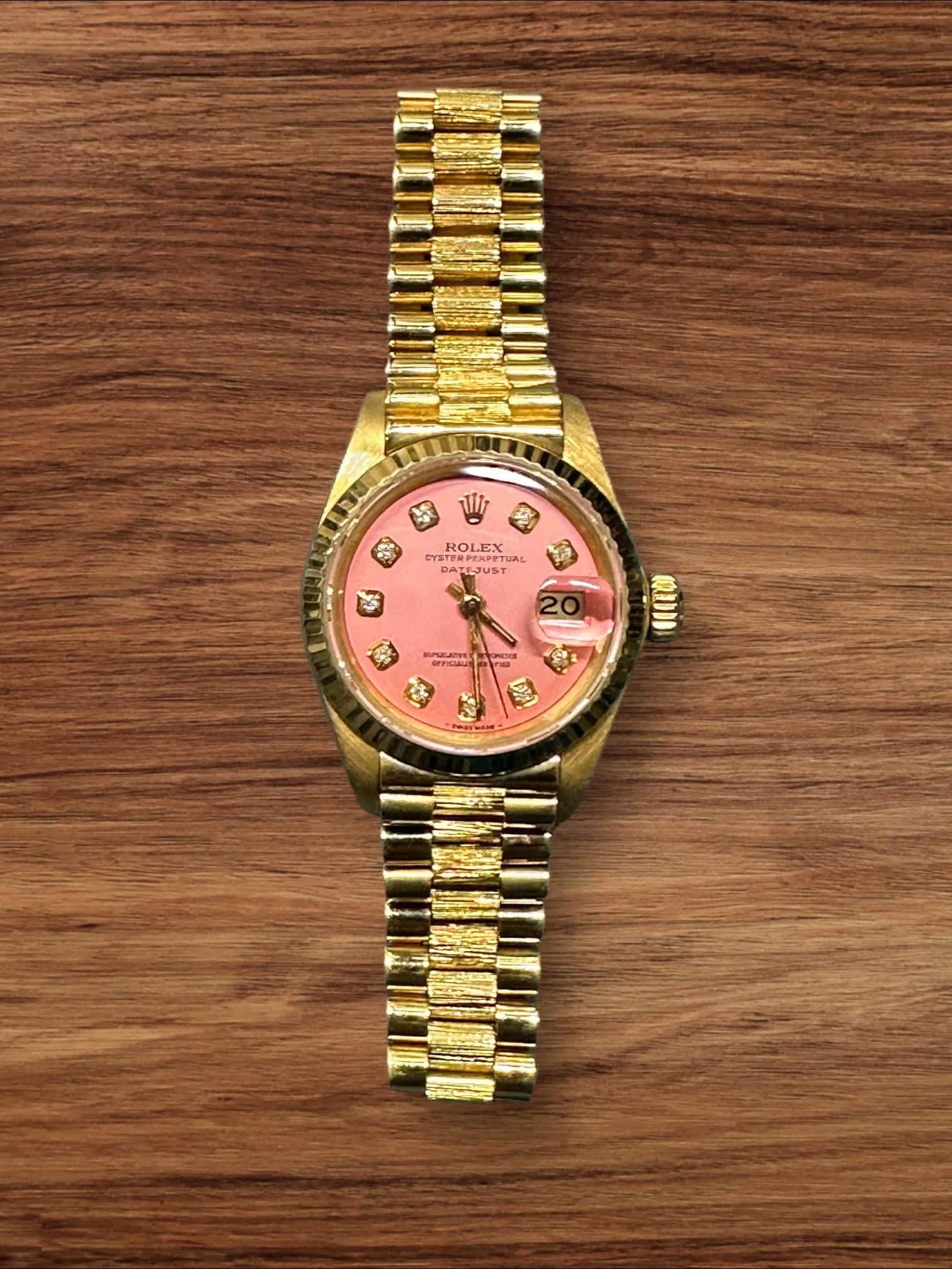 Elegant Rolex Lady President with pink dial and diamond hour markers.